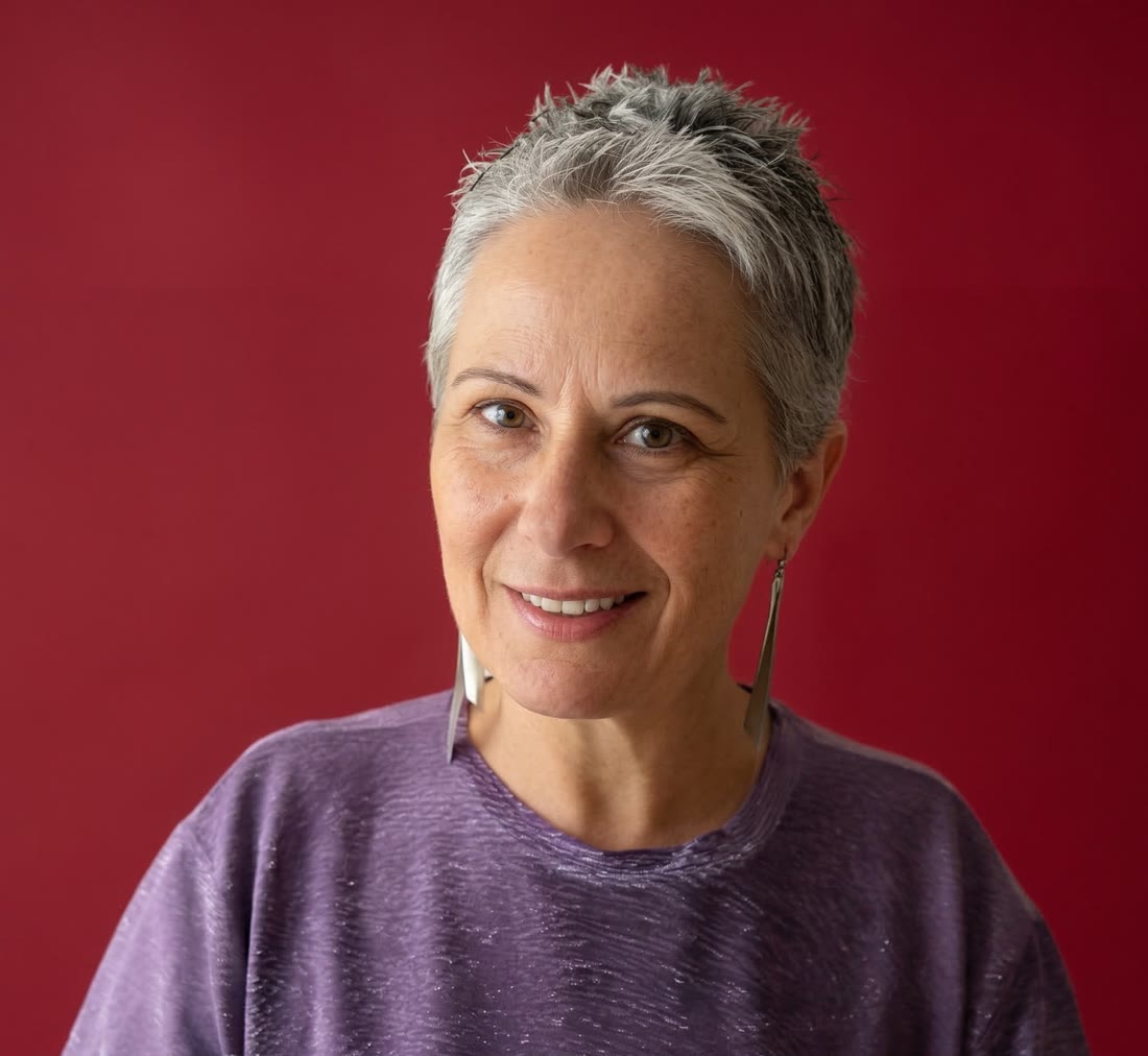 Lenira Senegaglia, de blusa roxa, sobre fundo vermelho.